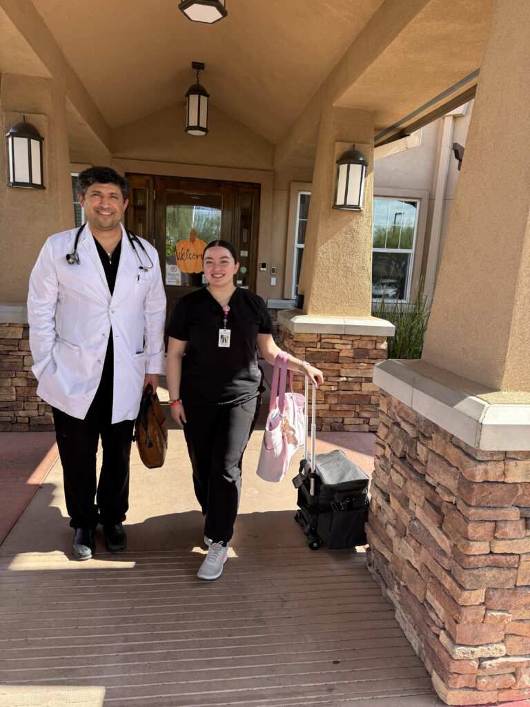 Dr. Kiyan Rad in a white coat with a Sanova medical assistant and a mobile medical bag outside a Tucson care community