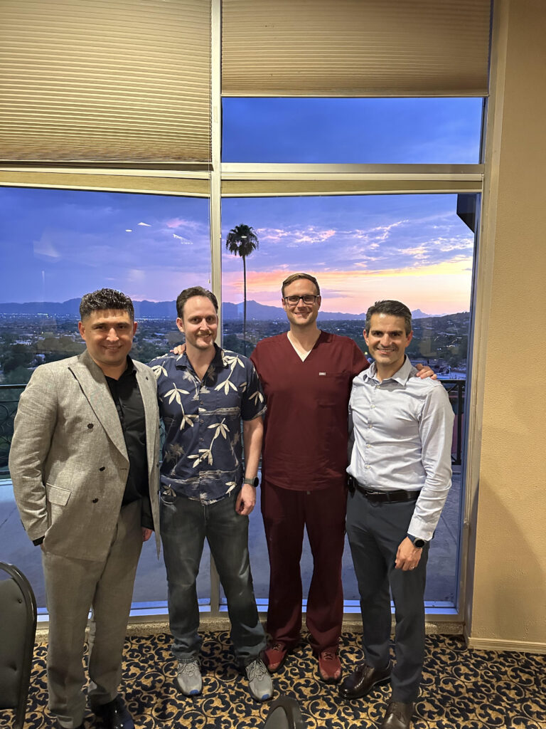 Physicians at an evening networking gathering hosted by Dr. Kiyan Rad and Sanova Medical Group at Skyline Country Club in Tucson, with a sunset view over the city and mountains