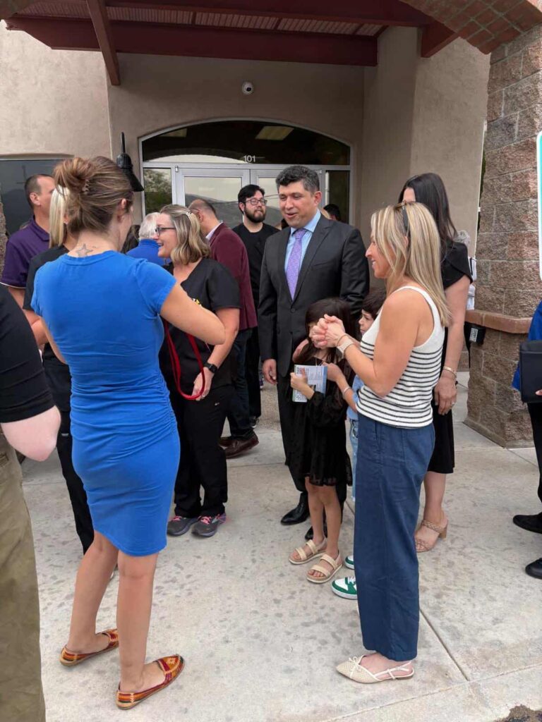 Guests gathered at the entrance of Sanova Urgent Care during the ribbon-cutting celebration